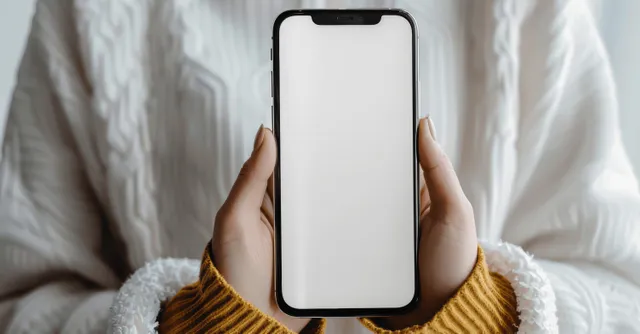 Woman holding smartphone with blank screen mockup, hands centered on soft bed background