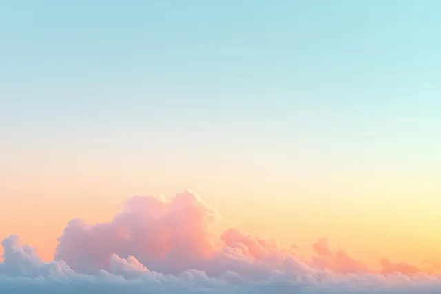Pastel sunrise clouds glowing softly above a clear blue sky