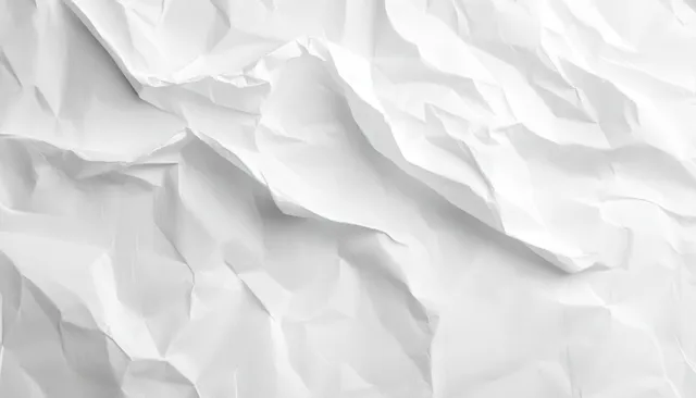 Crumpled white paper texture with deep creases and soft shadowed folds close-up