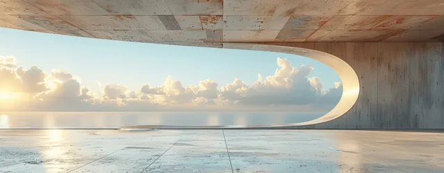 Empty concrete gallery interior with a curved opening showing bright blue sky and clouds.