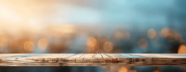 Wooden tabletop on blurred blue background with warm bokeh lighting and copy space