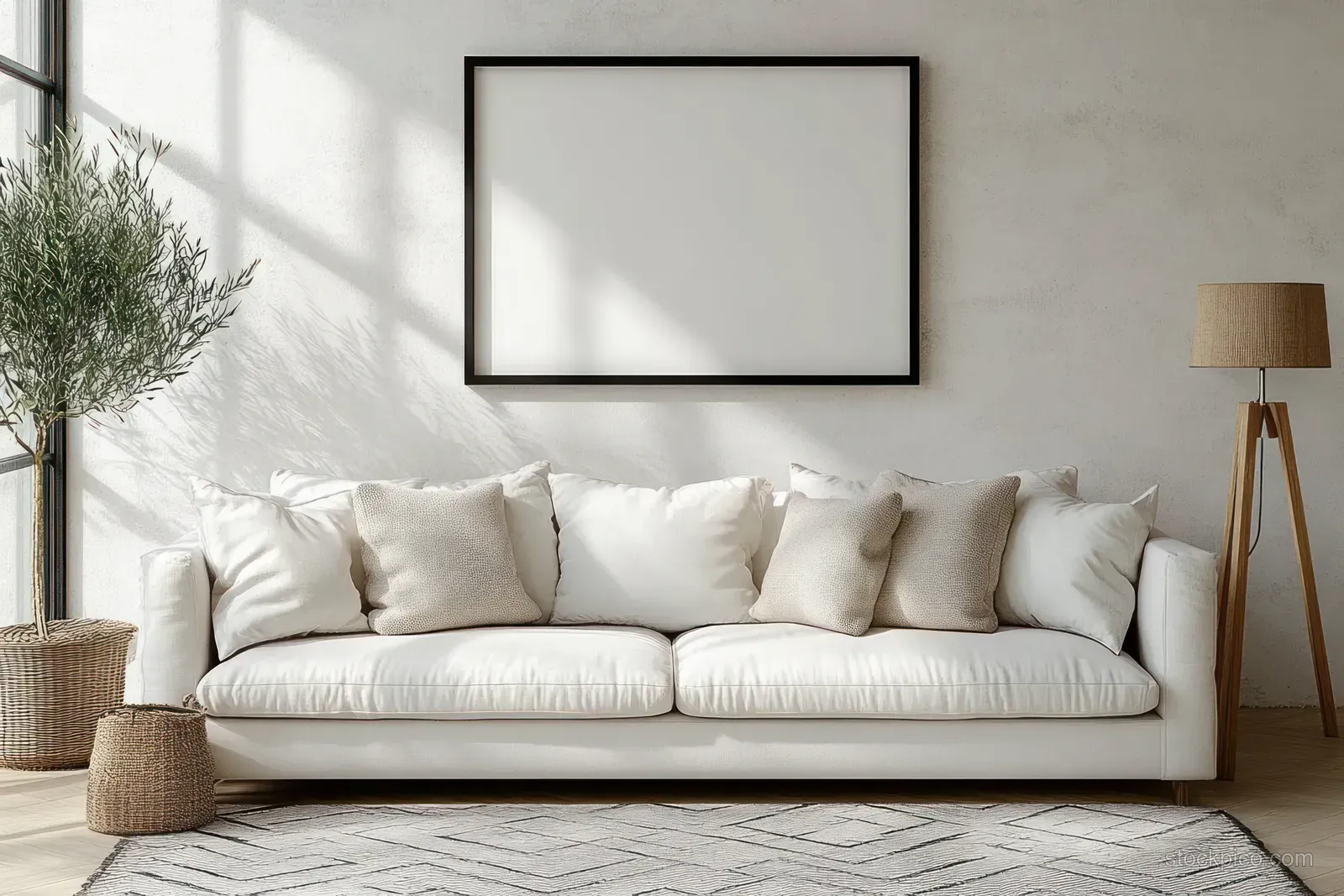 Minimalist living room interior with white sofa, textured pillows, patterned rug, floor lamp, and blank framed artwork.