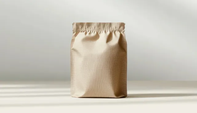 Minimal kraft pet food pouch standing on a soft neutral surface