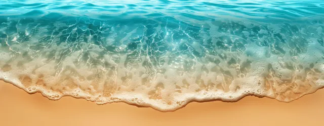 Turquoise ocean wave rolls onto a sandy beach under bright sunlight with foam and clear water.