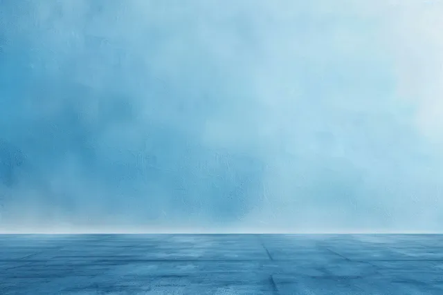Empty blue concrete floor meeting a softly textured wall gradient under calm light