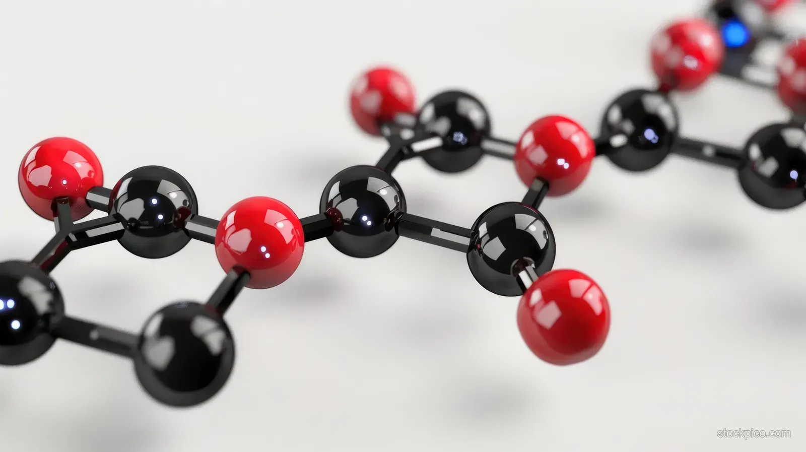 Black and red molecular spheres connected by rods in a ball-and-stick chain on a glossy white background.
