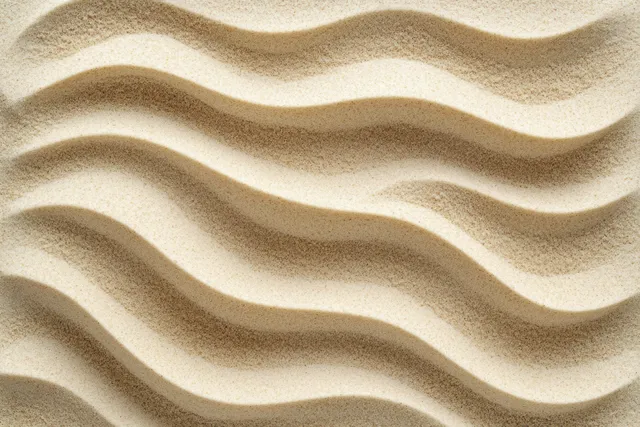 Close-up of wavy sand ripples forming rhythmic curves with soft light and shadow