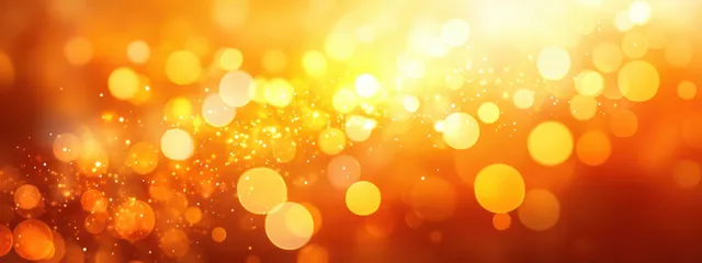 Soft orange and yellow bokeh circles shimmer across an abstract blurred background.