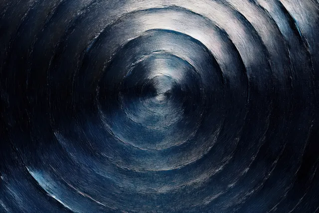 Close-up of a dark metal surface with concentric circular grooves and blue-gray reflective highlights.