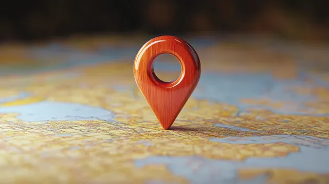 Red wooden location pin marker standing on a textured map with blurred backdrop