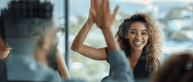 Smiling office team high-fiving during boardroom meeting with city skyline backdrop