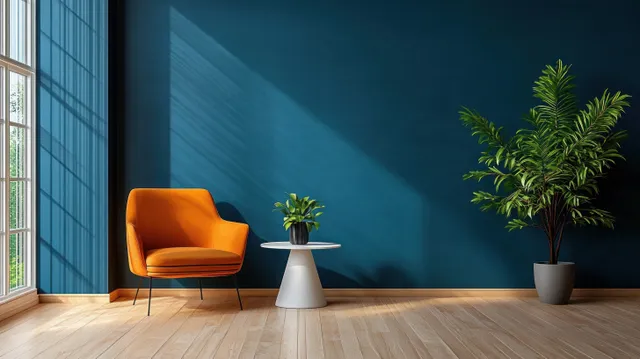 Orange armchair and white table with potted plants in a modern living room beside a blue wall.