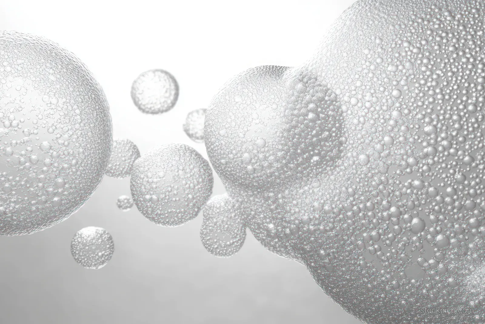 Transparent bubbles coated with tiny droplets float in a bright white, softly blurred background.