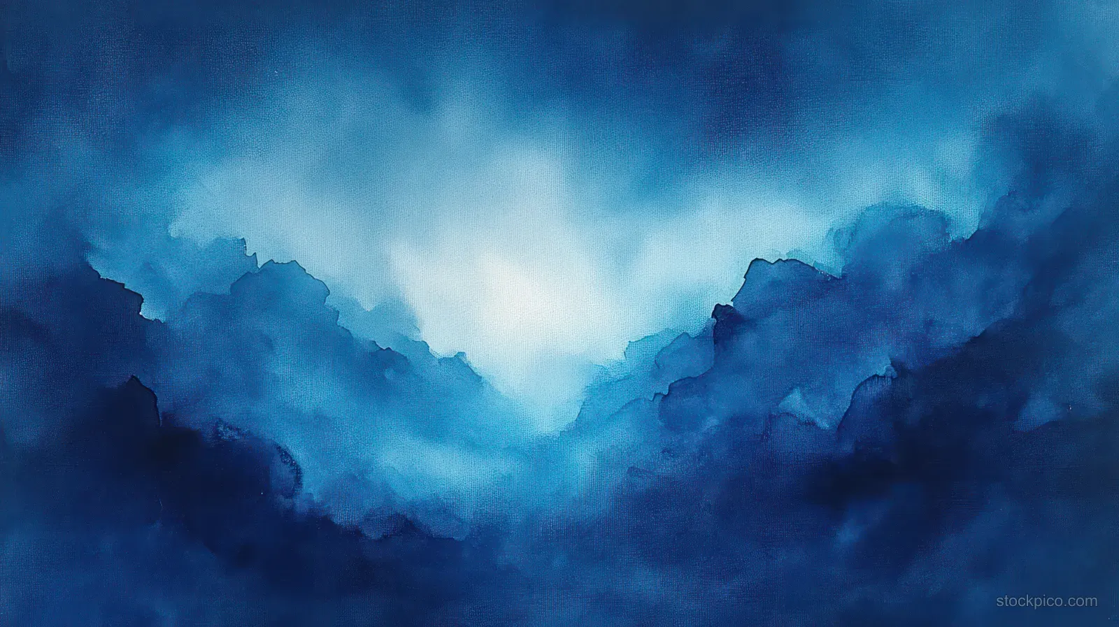 Blue mountain ridges disappear into thick fog with layered soft clouds and a faint glowing sky.