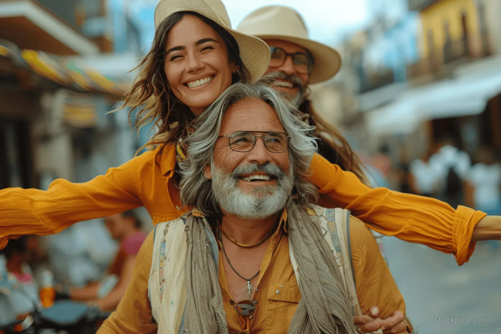 A smiling mature couple poses on a Barcelona street, with the woman on the man's shoulders.
