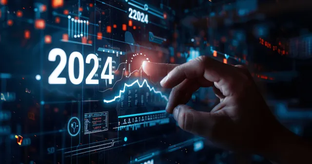 Hand updating 2024 growth chart on digital business dashboard with glowing metrics