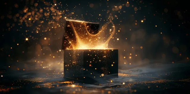 An open black box glows and releases golden sparks and misty light particles against a dark background.