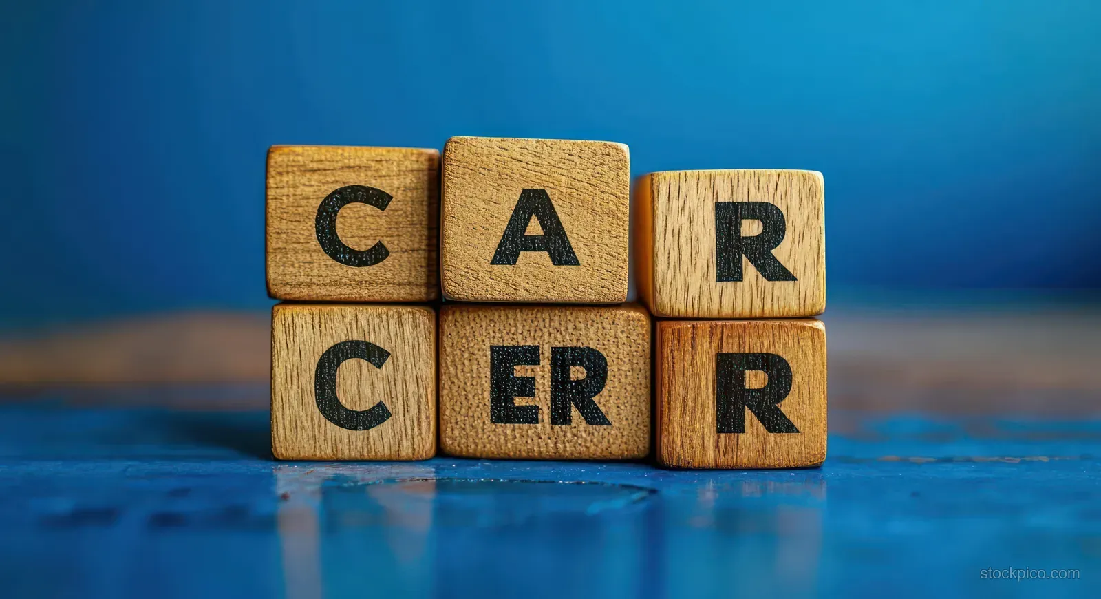 Wooden blocks arranged to spell CANCER with a blurred blue background behind them.