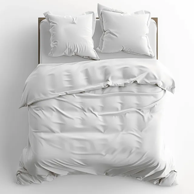 Two white pillows and a neatly made duvet on a tidy bed against a simple headboard.