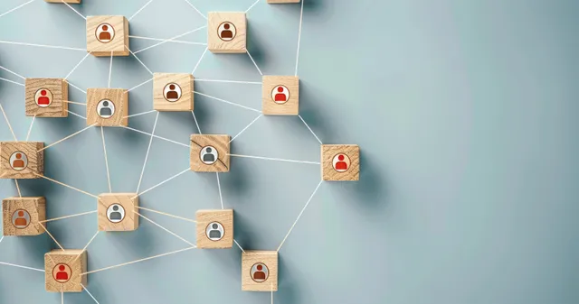 Linked employee icons form a network diagram on a light blueprint wall.