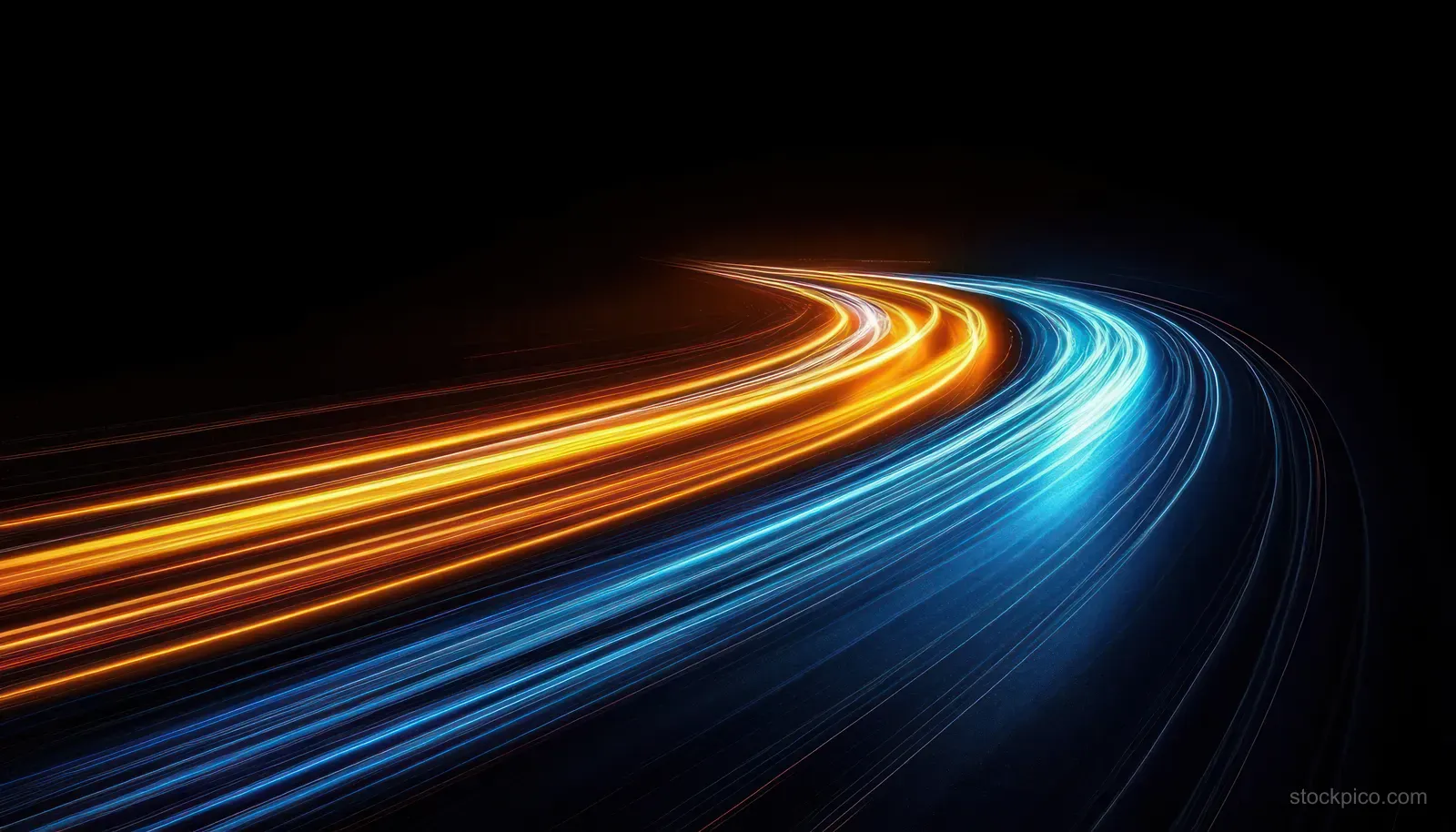 Long-exposure light trails curve along a night highway, glowing blue and orange on dark asphalt.