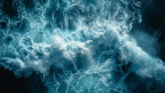 Drone top view of turquoise ocean waves crashing with white foam texture