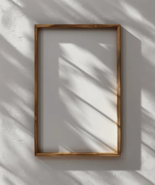 Vertical wooden picture frame on white wall with sharp sunlight shadows 3D render