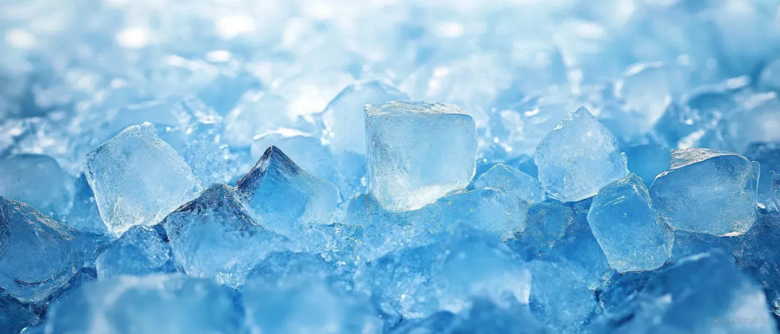 Shattered blue ice cubes and fragments create a frosty texture background with sparkling crystalline edges.