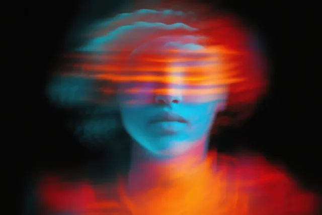 Close-up portrait with eyes obscured by orange and red horizontal light streaks over a dark background.