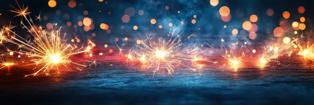 Sparklers shoot bright sparks and smoke across a dark Independence Day background with out-of-focus bokeh lights.