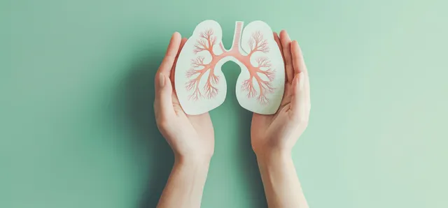 Hands Holding Paper Lungs on Mint Green Background for Health Care