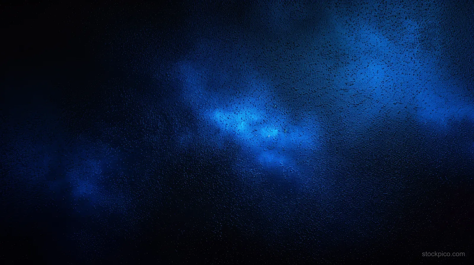 Abstract dark blue gradient with grainy glow and black negative space.