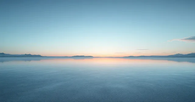 Still reflective water mirrors a clear blue sky with faint sunset glow along the horizon.