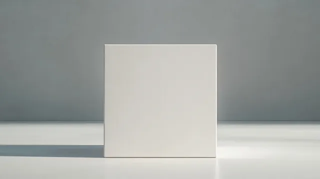 Minimalist white gift box standing in light gray cube display with soft shadows