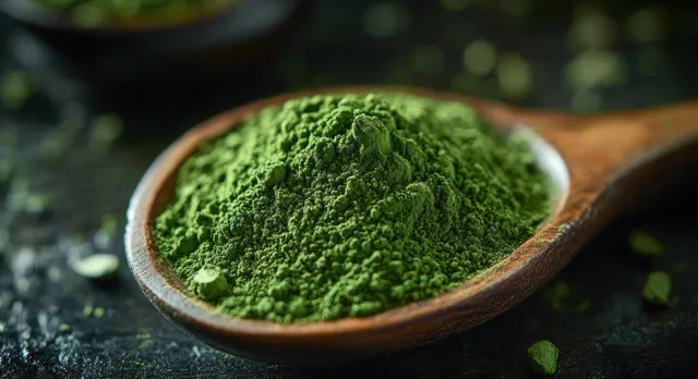 Close-up of vivid green powder heaped in a rustic wooden spoon on dark textured backdrop