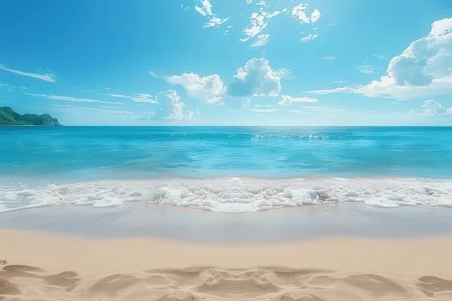 White sand beach meets turquoise ocean waves beneath a bright blue sky and distant headland.