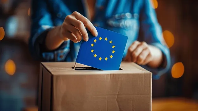 Woman’s hands insert a ballot into a box marked with an EU flag against a blue background.