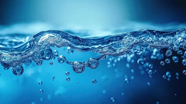 Close-up sparkling water surface with rising bubbles against vibrant blue background