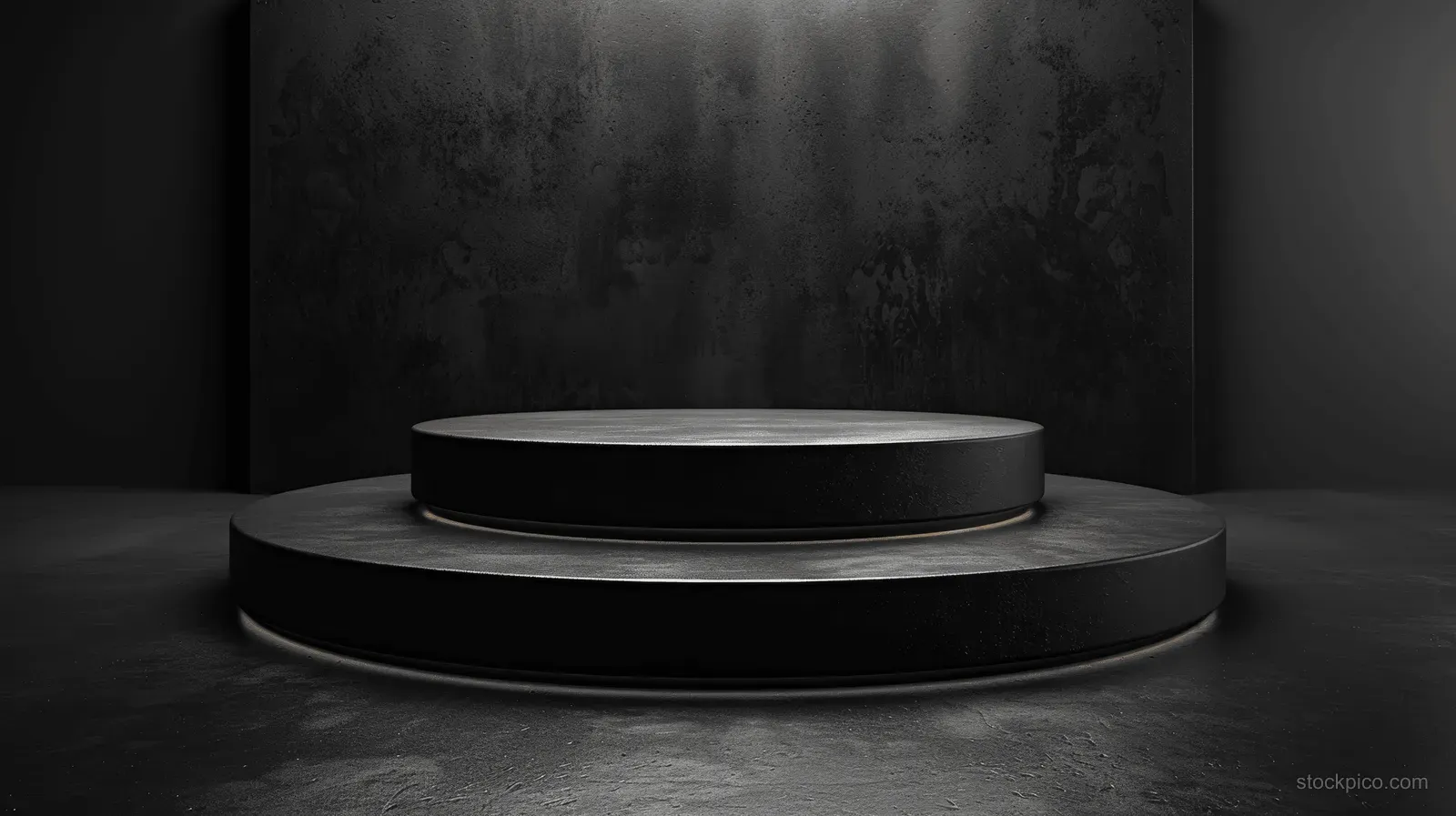 Black stacked round stages on a textured dark floor under a subtle spotlight.