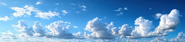 Blue sky with fluffy cumulus clouds drifting across a wide panoramic landscape