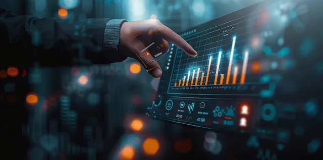 A person holds a smartphone while glowing investment charts and market statistics appear on a laptop screen.