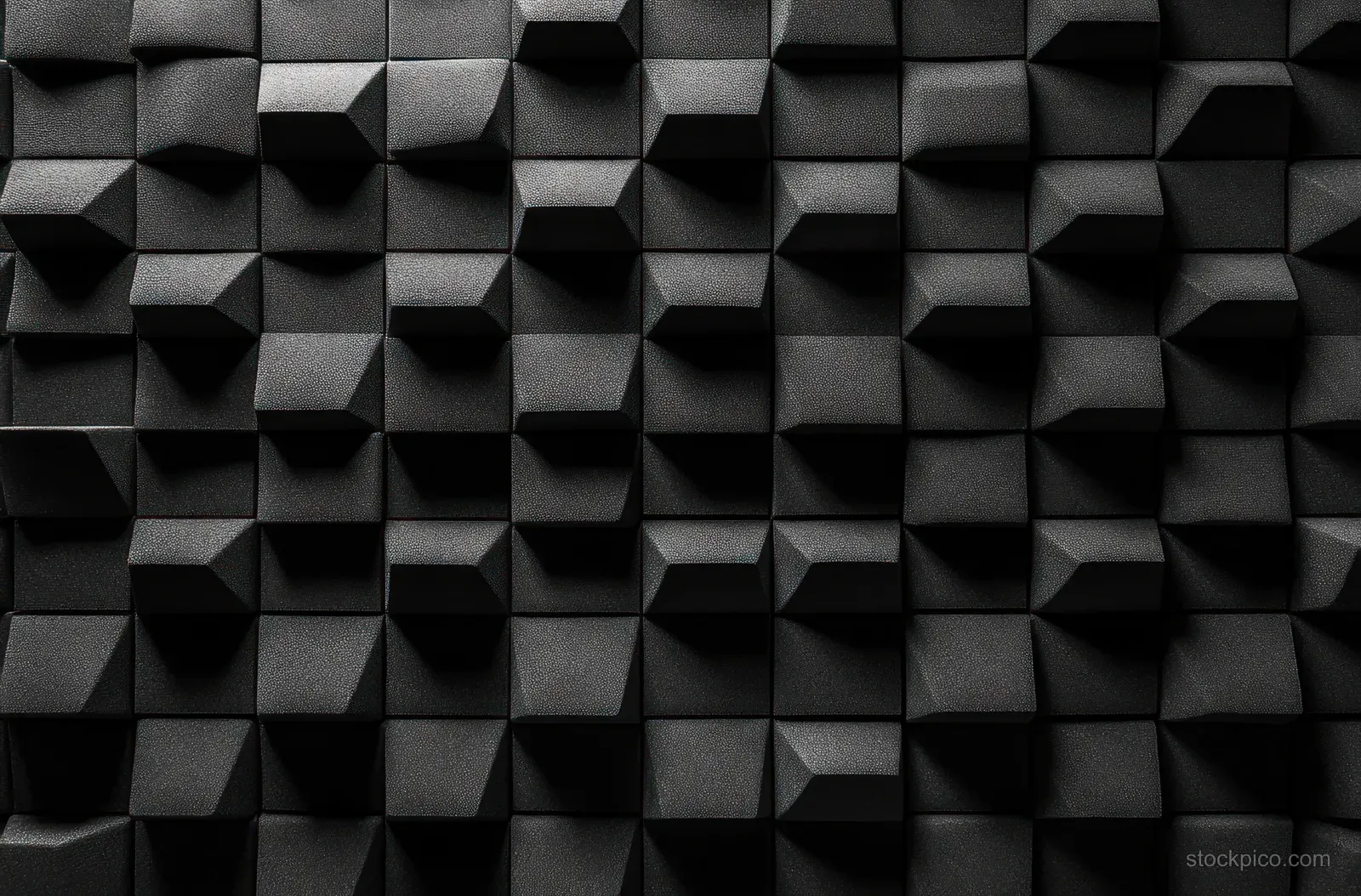 Close-up of a black 3D wall texture featuring raised rectangular and trapezoidal blocks in a geometric pattern with shadows and highlights.
