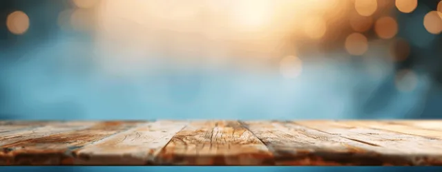 Weathered wooden tabletop foreground with blurred blue bokeh lights in the background.