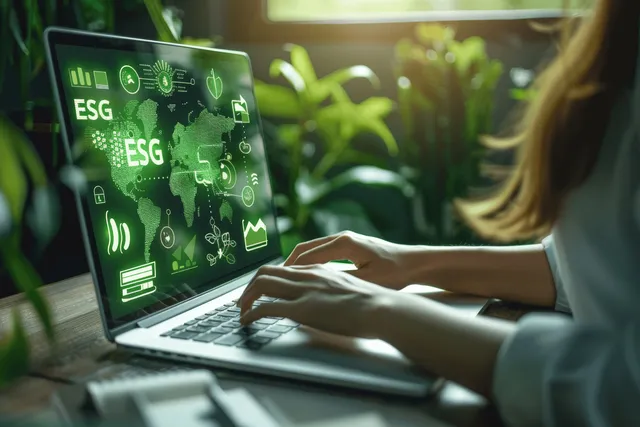 Woman analyzes ESG data on laptop with green sustainability icons on screen at desk