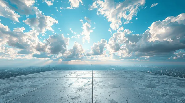 Concrete platform extends toward a distant skyline beneath a bright blue sky with layered clouds.