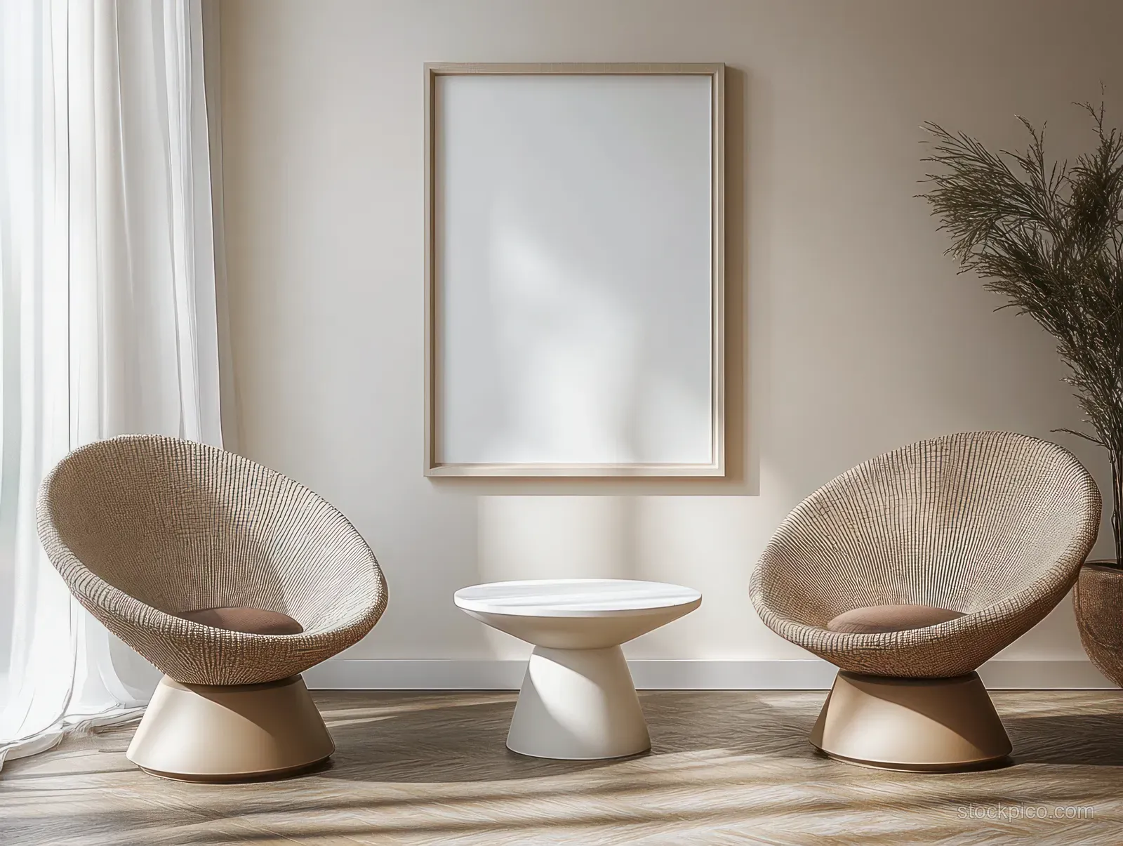 Two beige swivel chairs flank a round white pedestal table in a bright Scandinavian living room with framed wall art.
