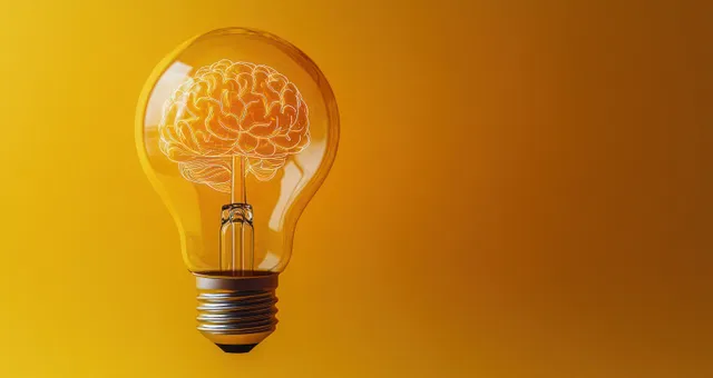 Glowing light bulb with brain filament inside on yellow backdrop symbolizing inspiration and ideas
