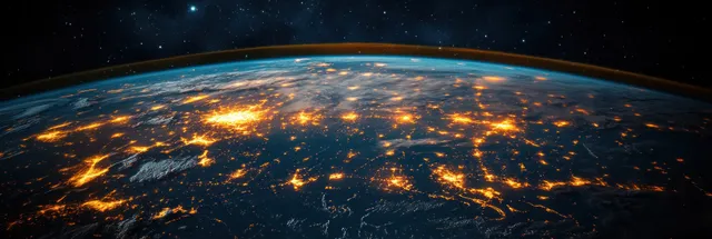 Earth at night from space shows Mediterranean city lights glowing along the coastline against a starry sky.