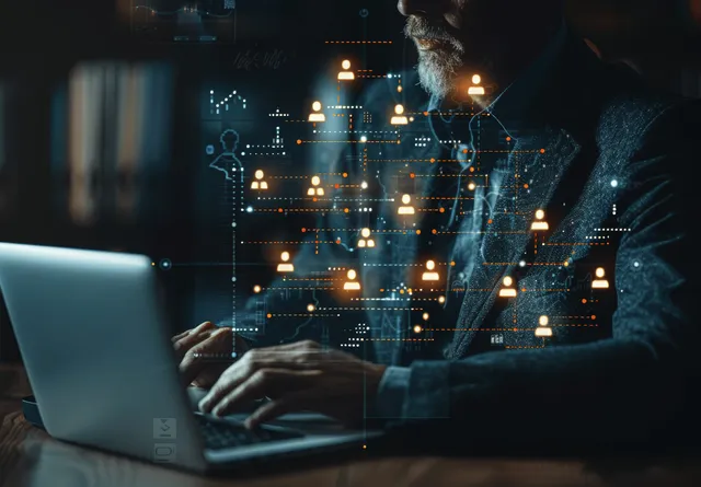 Businessman working on a laptop with glowing org chart and workflow nodes overlaying the scene.
