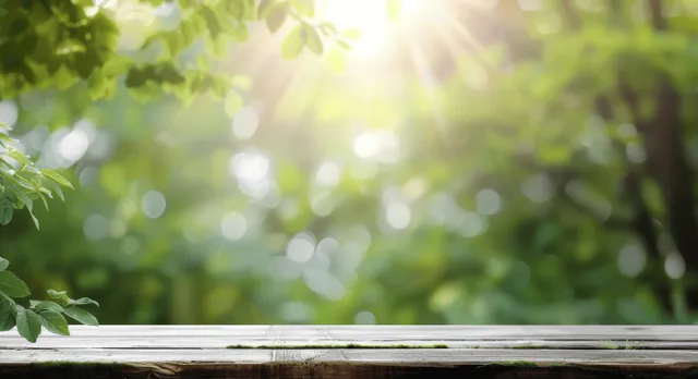 Wooden tabletop in the foreground with blurred green leaves and sunlit bokeh in the background.